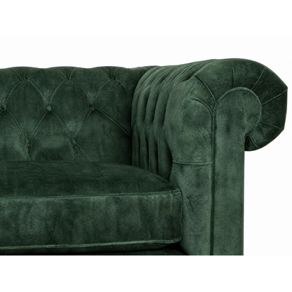 Green velvet sofa with tufted backrest on a white background