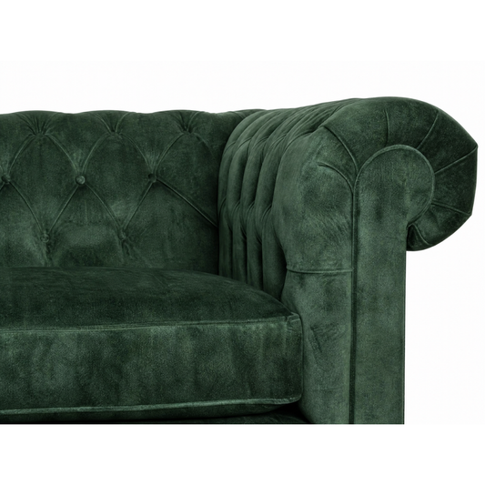 Green velvet sofa with tufted backrest on a white background