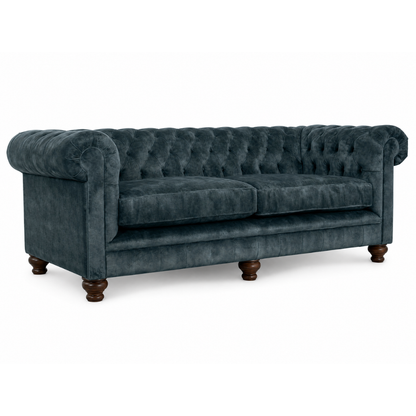 Blue velvet sofa with wooden legs on a white background