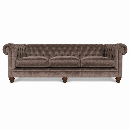 A classic three-seater sofa upholstered in textured taupe-brown velvet with deep button tufting on the backrest, rolled arms, and turned wooden legs, shown against a plain white background.