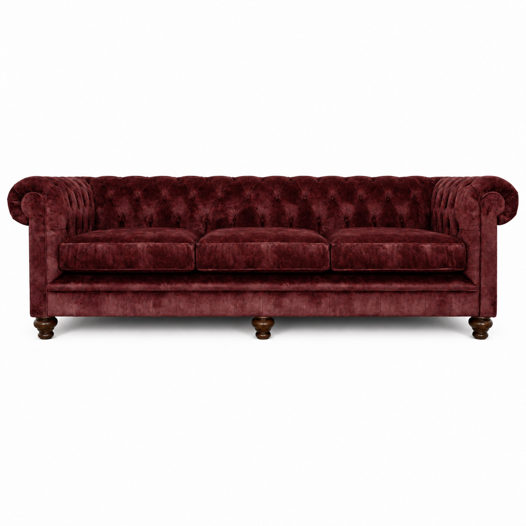 A classic Chesterfield-style three-seater sofa upholstered in deep burgundy velvet, featuring a tufted backrest, rolled arms, three loose seat cushions, and dark wooden turned legs, shown against a plain white background.