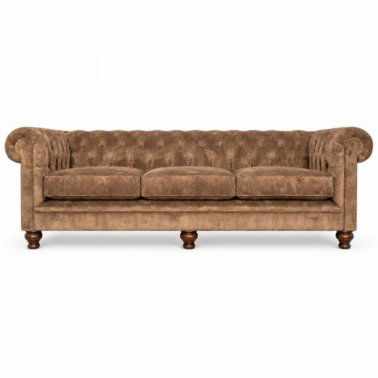 A classic Chesterfield-style sofa upholstered in brown tufted velvet, featuring rolled arms, three seat cushions, and turned wooden legs, shown against a plain white background.