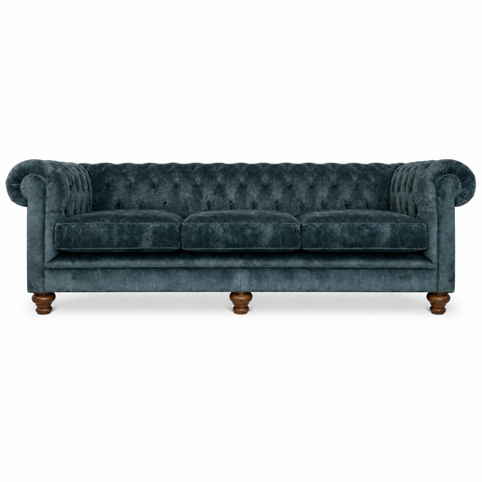 A classic Chesterfield-style three-seater sofa upholstered in dark teal velvet, featuring tufted detailing, rolled arms, and turned wooden legs, shown against a plain white background.