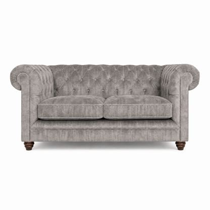 Gray velvet sofa with tufted backrest on a white background