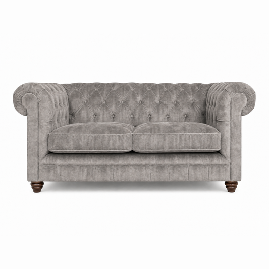 Gray velvet sofa with tufted backrest on a white background