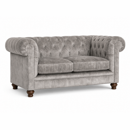 Gray velvet sofa with tufted backrest on a white background