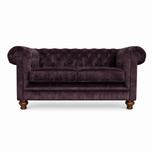 Purple velvet sofa with wooden legs on a white background