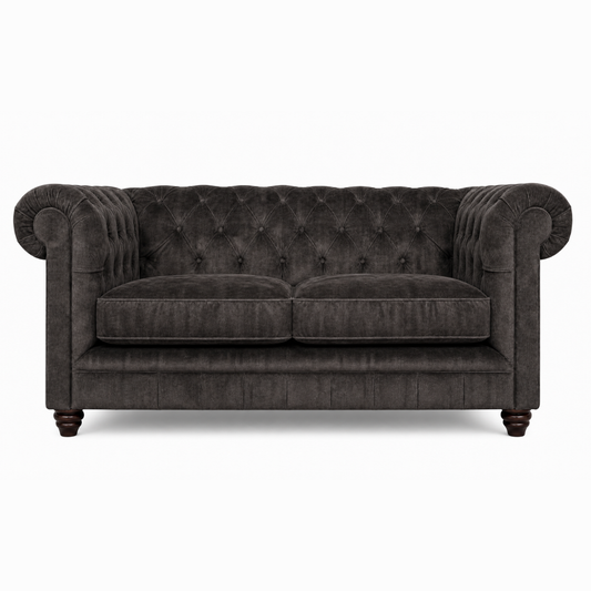 Dark gray tufted sofa on a white background