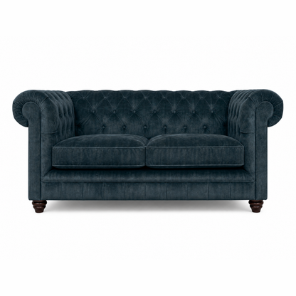 Blue velvet sofa with tufted backrest on a white background