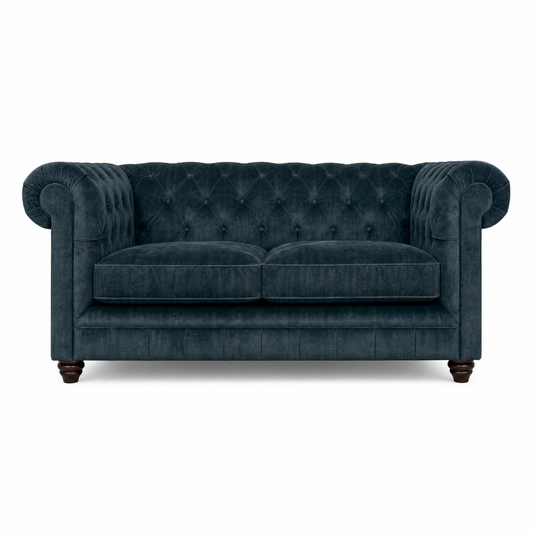 Blue velvet sofa with tufted backrest on a white background