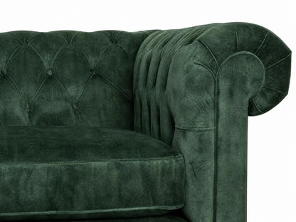 Green velvet sofa with tufted backrest on a white background