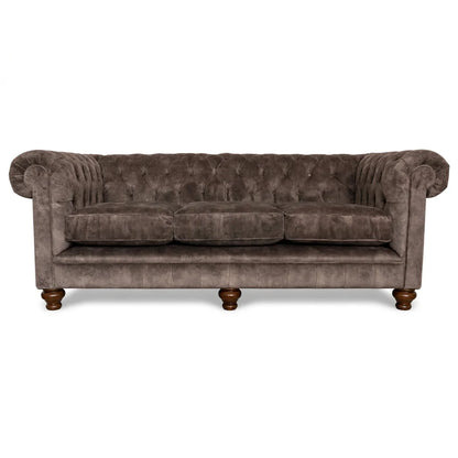 Brown velvet sofa with tufted backrest on a white background