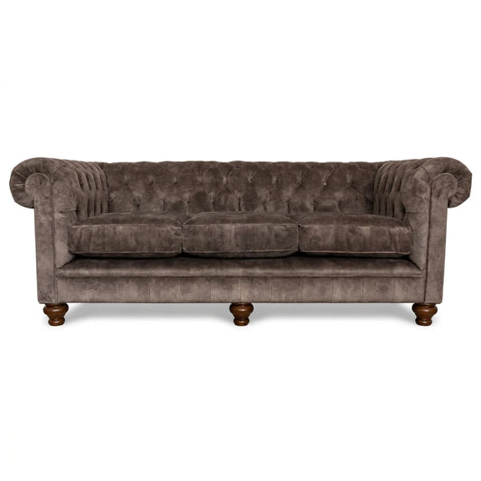 Brown velvet sofa with tufted backrest on a white background