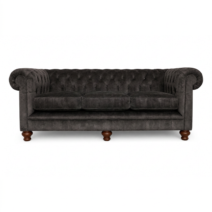 Dark gray tufted sofa with wooden legs on a white background