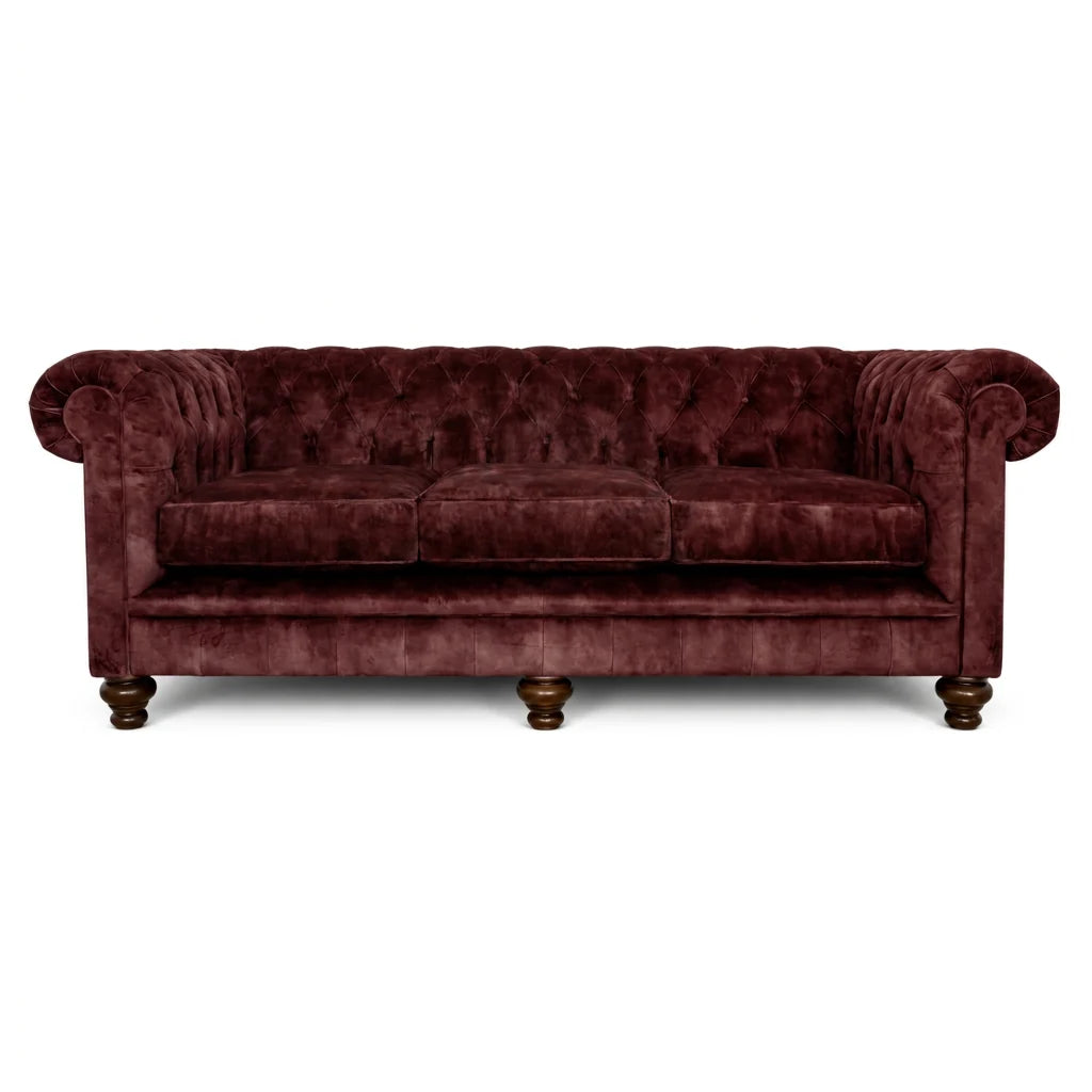 Burgundy velvet sofa with tufted backrest on a white background