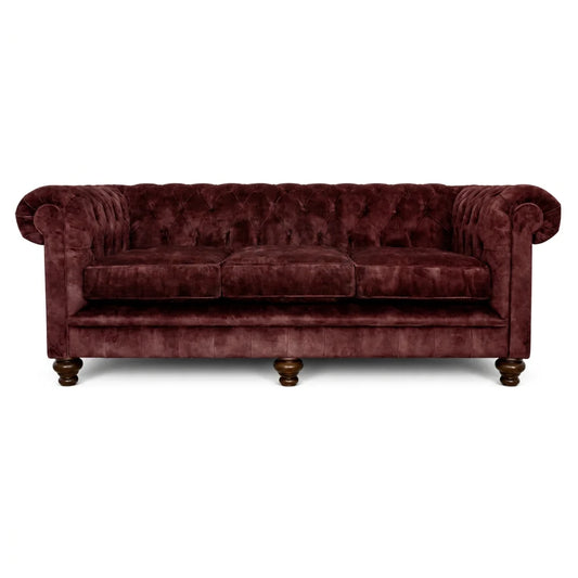 Burgundy velvet sofa with tufted backrest on a white background