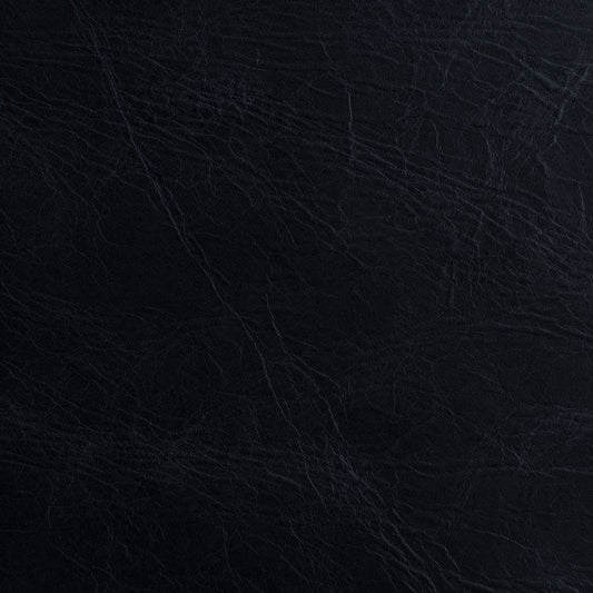 A close-up of a dark textured material, appearing as black leather or faux leather with subtle grain and fine creases.