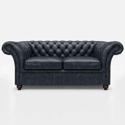 Dark gray leather sofa with tufted backrest on a white background