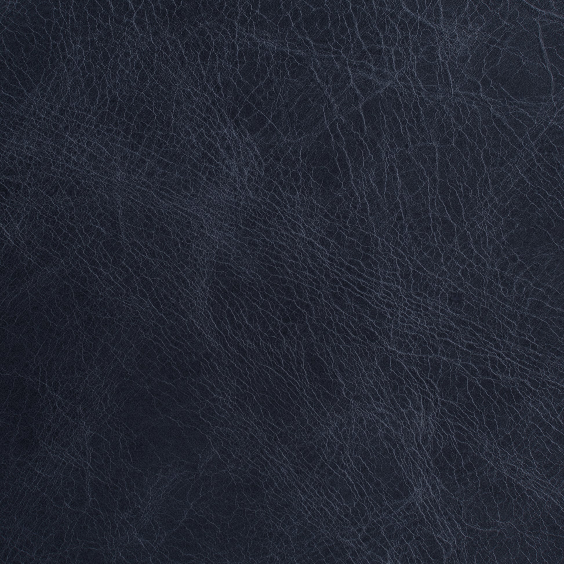 A close-up texture shot of dark navy blue leather with fine grain lines.