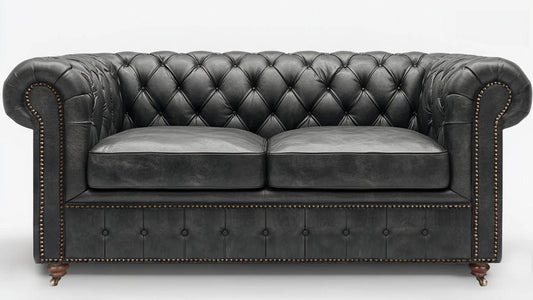 Grey leather chesterfield sofa on a white background